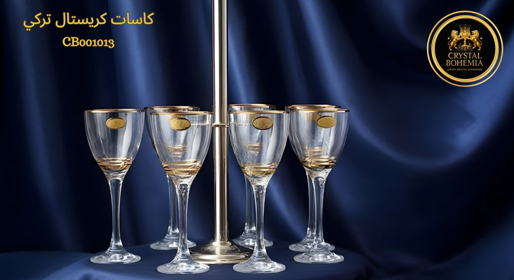 Set of six champagne glasses with gold accents on a blue fabric background